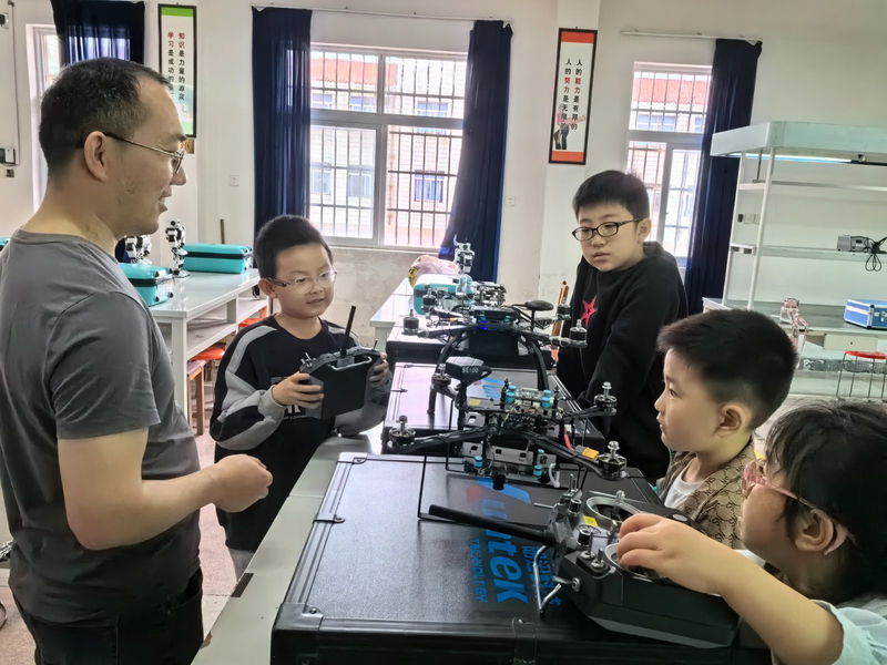 4、小学生在老师的指导下操作无人机.jpg